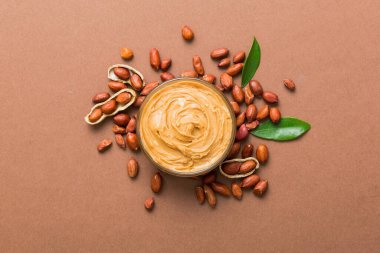 Arka planda bir kase fıstık ezmesi ve fıstık. Kopyalama alanı olan üst görünüm. Küçük kasede kremalı fıstıklı makarna.