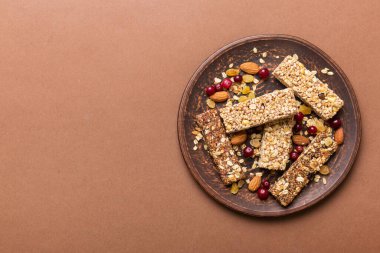 Arka planda çeşitli granola barlar var. Mısır gevreği gofretleri. Yulaf, fındık ve böğürtlenli kahvaltı barları, yakın çekim. Süper yiyecek konsepti.
