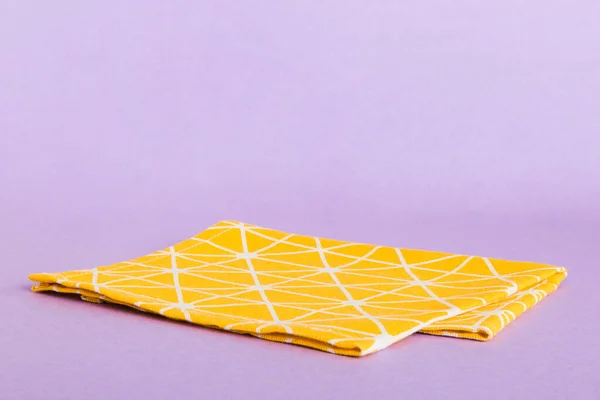 stock image top view with yellow empty kitchen napkin isolated on table background. Folded cloth for mockup with copy space, Flat lay. Minimal style.