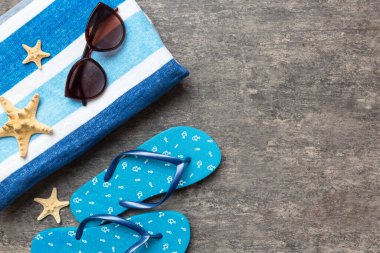 Yaz yolculuğu konsepti. Parmak arası terlikler, güneş gözlükleri ve beyaz üzerine deniz yıldızı. Renkli arkaplanda üst görünüm.