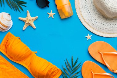 Woman swimwear and beach accessories flat lay top view on colored background Summer travel concept. bikini swimsuit, straw hat and seasheels. Copy space Top view.