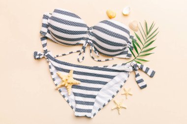 Kadın mayo ve plaj aksesuarları renkli arka plan yaz seyahati konseptine düz bir görünüm kazandırıyordu. Bikini mayo, hasır şapka ve deniz topuklu ayakkabı. Üst görünümü kopyala.