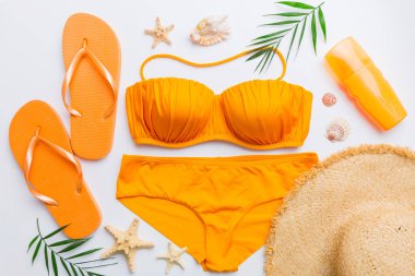 Woman swimwear and beach accessories flat lay top view on colored background Summer travel concept. bikini swimsuit, straw hat and seasheels. Copy space Top view.