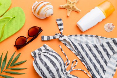 Kadın mayo ve plaj aksesuarları renkli arka plan yaz seyahati konseptine düz bir görünüm kazandırıyordu. Bikini mayo, hasır şapka ve deniz topuklu ayakkabı. Üst görünümü kopyala.