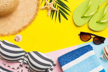 Plaj aksesuarları hasır şapka ve deniz kabuğu renkli masada. Yaz konsepti arka planı.