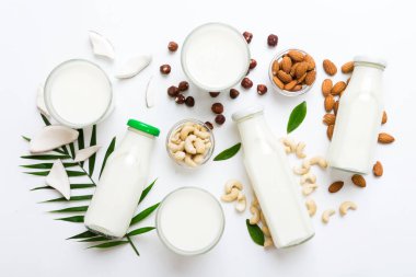 Set or collection of various vegan milk almond, cashew, on table background. Vegan plant based milk and ingredients, top view. clipart