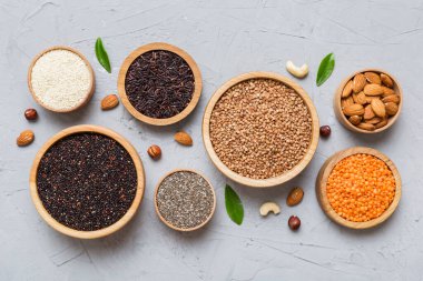 Smal Bowl 'da renkli arka planda çeşitli süper yiyecekler. Pirinç, chia, kinoa, mercimek, fındık, susam tohumu, badem gibi süper yiyecekler. üst görünüm kopyalama alanı.