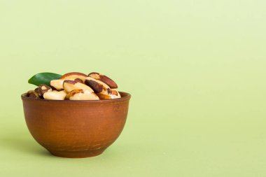 Fresh healthy Brazil nuts in bowl on colored table background. Top view Healthy eating bertholletia concept. Super foods.