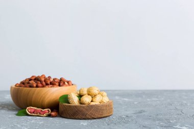 Fresh healthy peanuts in bowl on colored table background. Top view Healthy eating bertholletia concept. Super foods.