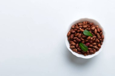 Fresh healthy peanuts in bowl on colored table background. Top view Healthy eating bertholletia concept. Super foods.