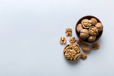 Fresh healthy walnuts in bowl on colored table background. Top view Healthy eating bertholletia concept. Super foods.