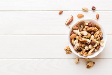 mixed nuts in bowl. Mix of various nuts on colored background. pistachios, cashews, walnuts, hazelnuts, peanuts and brazil nuts.