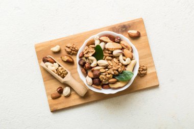 mixed nuts in bowl. Mix of various nuts on colored background. pistachios, cashews, walnuts, hazelnuts, peanuts and brazil nuts.