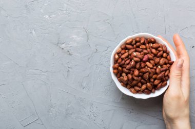 Kadın elleri tahta kaseyi fıstıkla tutuyor. Sağlıklı yemek ve atıştırmalık. Farklı fındıklı vejetaryen atıştırmalıkları..