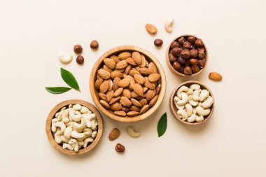 Renkli masadaki ahşap kasede fındık çeşitleri. Ceviz, fındık, ceviz, badem. Fındık Üst görünümü ile kopyalama alanını karıştır.