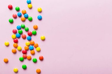 Renkli arka planda karışık renkli şeker koleksiyonu. Düz yerde, üst tarafta. Renkli çikolata kaplı şeker çerçevesi.