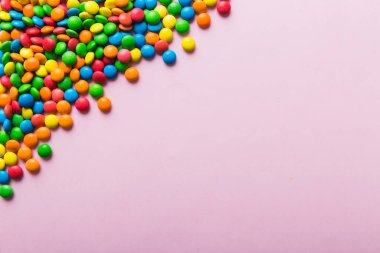 Renkli arka planda karışık renkli şeker koleksiyonu. Düz yerde, üst tarafta. Renkli çikolata kaplı şeker çerçevesi.
