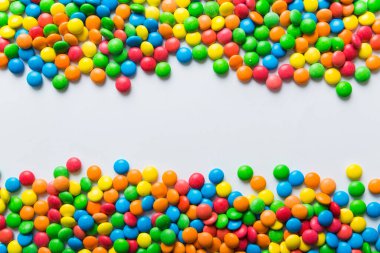 Renkli arka planda karışık renkli şeker koleksiyonu. Düz yerde, üst tarafta. Renkli çikolata kaplı şeker çerçevesi.
