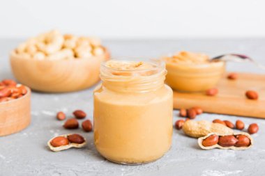 Arka planda bir kase fıstık ezmesi ve fıstık. Kopyalama alanı olan üst görünüm. Küçük kasede kremalı fıstıklı makarna.