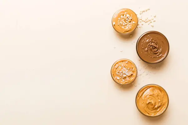 Stock image Glass jar with peanut butter on table background, top view space for text and close up.