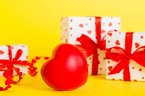 stock image gift box with red bow and red heart on colored background. Perspective view. Flat lay.