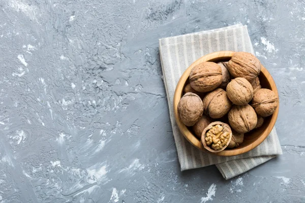 Fresh healthy walnuts in bowl on colored table background. Top view Healthy eating bertholletia concept. Super foods.
