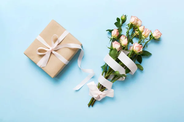 stock image design concept with pink rose flower and gift box on colored table background top view. Happy Holiday, Mothers day, birthday concept. Romantic flat lay composition.