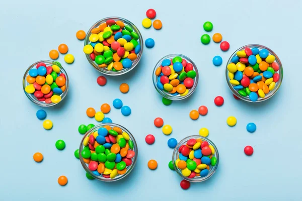 different colored round candy in bowl and jars. Top view of large variety sweets and candies with copy space.