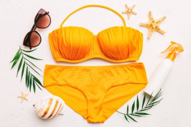 Kadın mayo ve plaj aksesuarları renkli arka plan yaz seyahati konseptine düz bir görünüm kazandırıyordu. Bikini mayo, hasır şapka ve deniz topuklu ayakkabı. Üst görünümü kopyala.