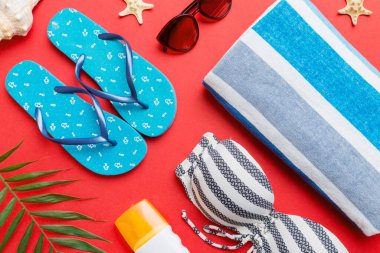 Kadın mayo ve plaj aksesuarları renkli arka plan yaz seyahati konseptine düz bir görünüm kazandırıyordu. Bikini mayo, hasır şapka ve deniz topuklu ayakkabı. Üst görünümü kopyala.