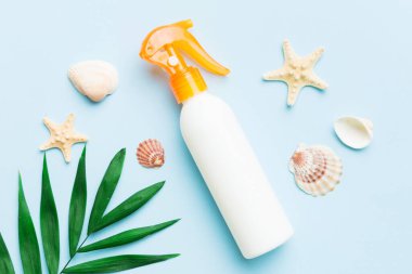 Güneş kremi şişesi. Güneş korumalı krem ve tropik yeşil yapraklı deniz kabukları olan bir şişe..