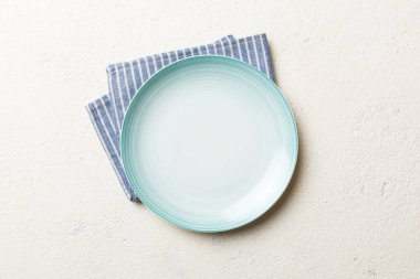 Renkli arkaplanda üst görünüm yiyecek için mavi tabak üzerinde boş. Tasarımınız için boşluk olan peçeteye boş tabak.