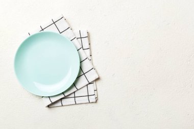 Renkli arkaplanda üst görünüm yiyecek için mavi tabak üzerinde boş. Tasarımınız için boşluk olan peçeteye boş tabak.