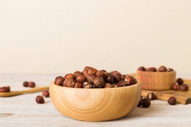 Wooden bowl full of hazelnuts on table background. Healthy eating concept. Super foods.