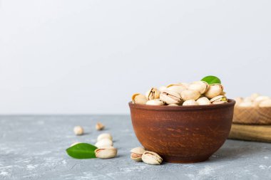 Renkli masa arkasında kasede taze ve sağlıklı Pistachio tabağı. Üst Manzara. Sağlıklı beslenme konsepti. Süper Yiyecekler.