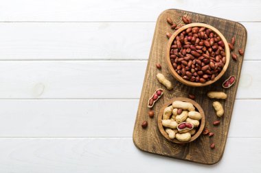 Fresh healthy peanuts in bowl on colored table background. Top view Healthy eating bertholletia concept. Super foods.