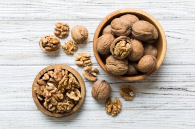Fresh healthy walnuts in bowl on colored table background. Top view Healthy eating bertholletia concept. Super foods.