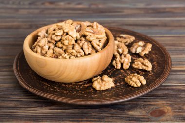 Fresh healthy walnuts in bowl on colored table background. Top view Healthy eating bertholletia concept. Super foods.