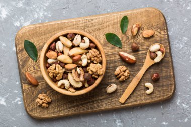 mixed nuts in bowl. Mix of various nuts on colored background. pistachios, cashews, walnuts, hazelnuts, peanuts and brazil nuts.