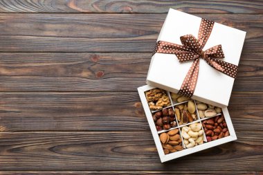 Various varieties of nuts lying in paper box on table background. Top view. Healthy food. Close up, copy space, top view, flat lay. Walnut, pistachios, almonds, hazelnuts and cashews.