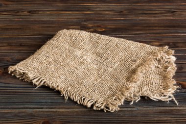 Old burlap fabric napkin, sackcloth on table background. top view with copy space.