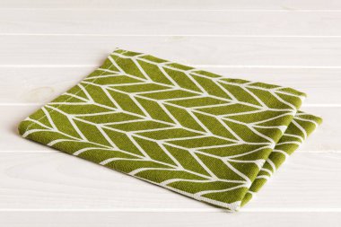 top view with green kitchen napkin isolated on table background. Folded cloth for mockup with copy space, Flat lay. Minimal style.