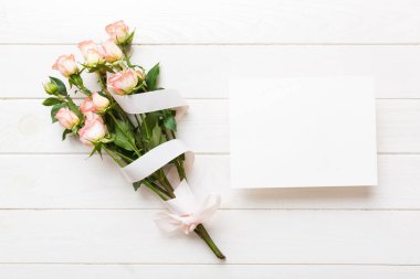 Renkli masa arkasında taze güller olan bayram kartı modeli tasarım için fotokopi alanı oluşturun.