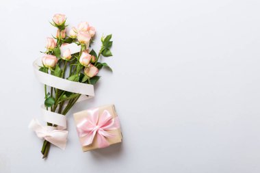 Pembe gül çiçekli tasarım konsepti ve renkli masa arkası manzaralı hediye kutusu. Mutlu Noeller, Anneler Günü, doğum günü konsepti. Romantik düz konum.