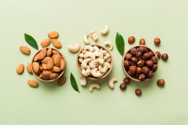 Renkli masadaki ahşap kasede fındık çeşitleri. Ceviz, fındık, ceviz, badem. Fındık Üst görünümü ile kopyalama alanını karıştır.