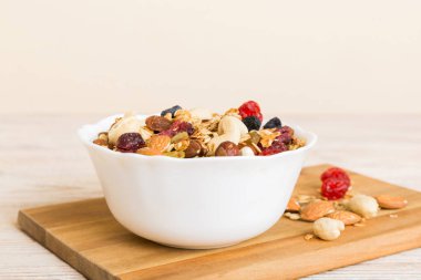 Sağlıklı bir kahvaltı hazırlıyorum. Bir kasede çeşitli kurutulmuş meyve ve fındıklı granola. Sağlıklı tatlı kavramı. Düz konum, kopyalama alanı olan üst görünüm.