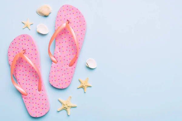 stock image Flat lay composition with flip flops and seashell on colored background. Space for text top view.