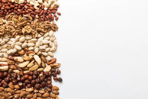 different nuts frame background. Close up, top view, flat lay with vopy space. Walnut, pistachios, almonds, hazelnuts and cashews.