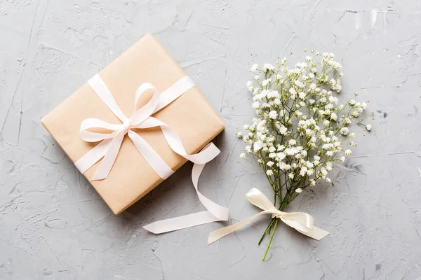 stock image Gift or present box and flower gypsophila on light table top view. Greeting card. Flat lay style with copy space.