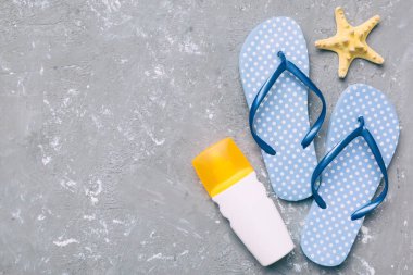 Flat lay composition with flip flops and seashell on colored background. Space for text top view.